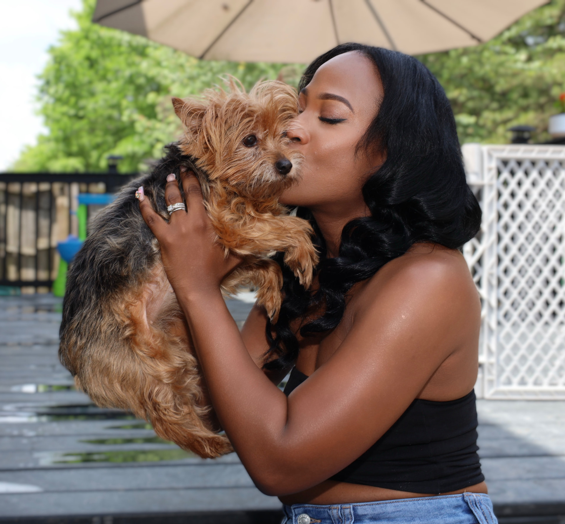 Daphne kissing a Yorkie on the back deck
